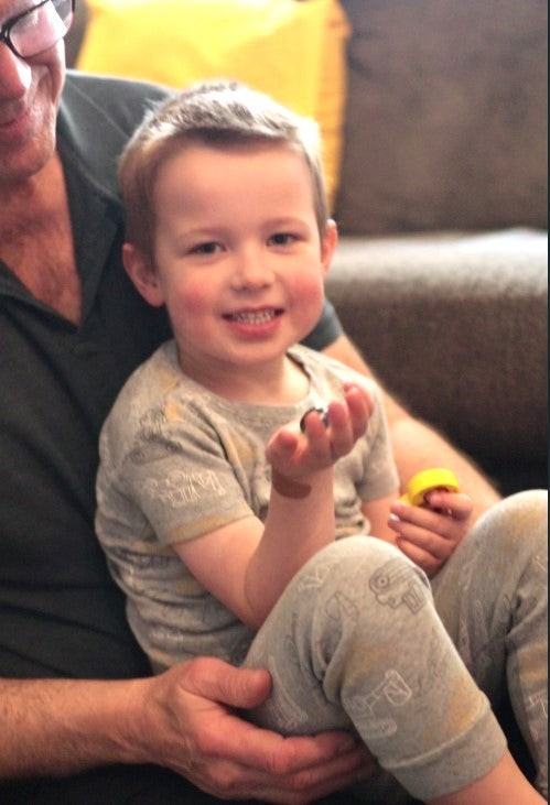 preschool boy holding bedtime board game gems and a game piece